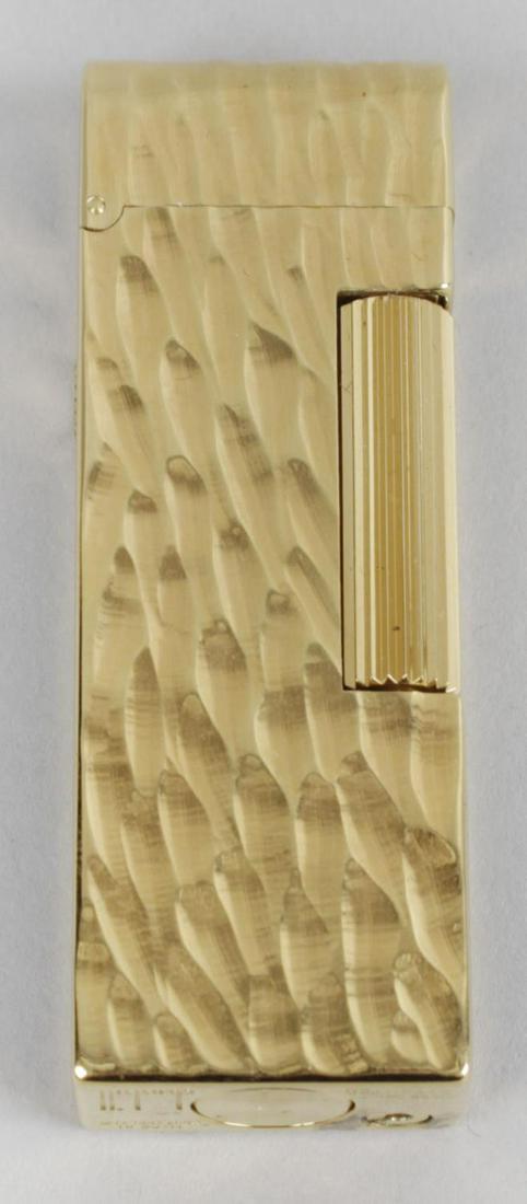 A gold plated Dunhill cigarette lighter, of rectangular: A gold plated Dunhill cigarette lighter, of rectangular form with domed hinged cover, the front and reverse panels with tree bark effect decoration, and black lacquer side panels, 2.75 (7cm) high, in