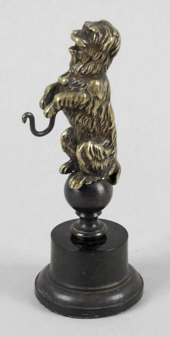 A 19th century bronze pocket watch stand, modelled as a: A 19th century bronze pocket watch stand, modelled as a terrier type dog, seated upon his rear legs in begging pose, upon a circular plinth base, 4.75 (12cm) high.
