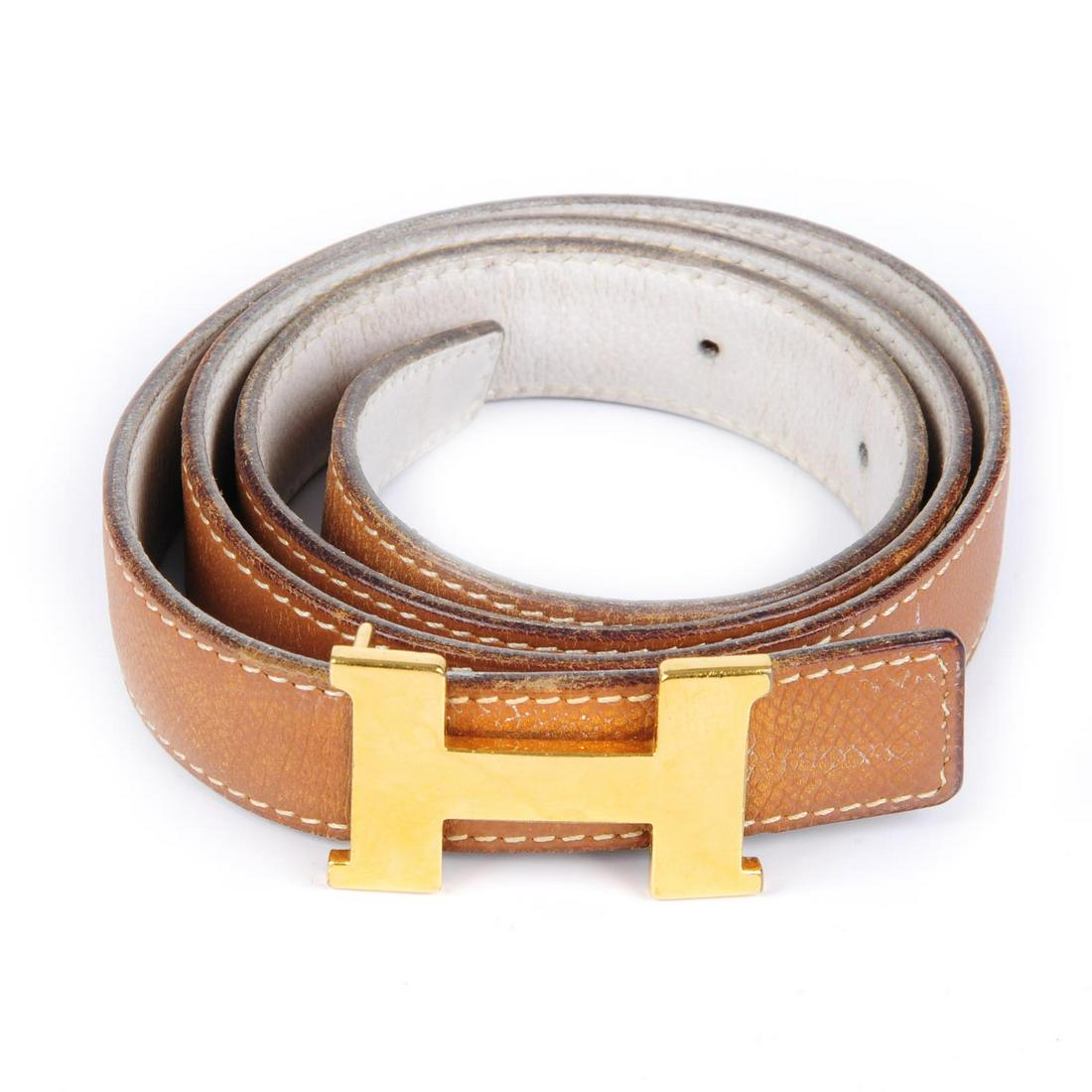 HERMÈS - a ladies thin reversible logo buckle belt.: HERMÈS - a ladies thin reversible logo buckle belt. Designed with tan leather to one side and white leather to the other, featuring maker's reversible classic gold-tone 'H' buckle. Stamped Hermès Pa