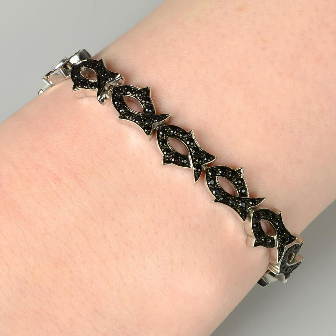 An 18ct gold sapphire 'Tattoo' bracelet, by Stephen: An 18ct gold sapphire 'Tattoo' bracelet, by Stephen Webster. Hallmarks for London, 2004. Length 16.4cms. 22.2gms.