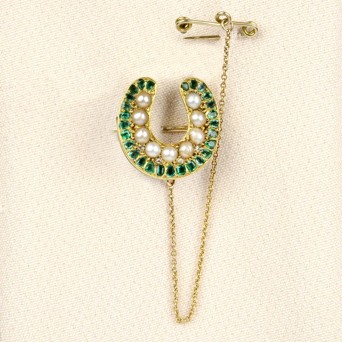 A mid Victorian Royal Presentation 15ct gold emerald: A mid Victorian Royal Presentation 15ct gold emerald and split pearl horseshoe brooch.Engraved 'From, Prince of Wales, Dec'r 1866'.Length 1.7cms. 4.9gms.