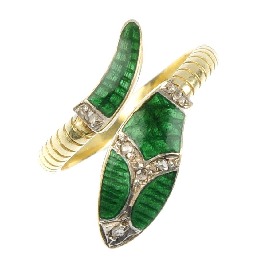 A diamond and green enamel snake ring. Of crossove: A diamond and green enamel snake ring. Of crossover design, the green guilloche enamel head and tail with diamond point accents to the scale detailed band. Unhallmarked . Weight 4.43gms. The ring is i