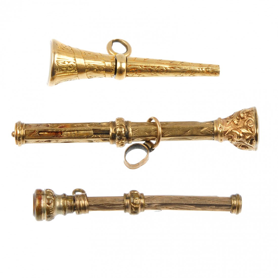 Two early 20th century gold plated pencils and a w: Two early 20th century gold plated pencils and a watch key fob. To include a retractable pencil with scroll engraved decoration and chalcedony base, a smaller retractable pencil of similar design with