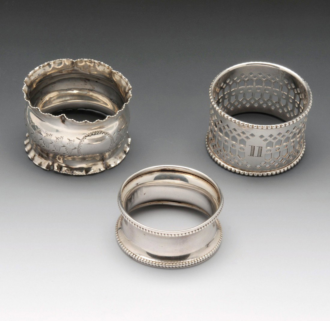 An Edwardian silver napkin ring.: An Edwardian silver napkin ring with flared frilled rim, hallmarked Joseph Gloster Ltd Birmingham 1907. Together with an early twentieth century example of plain waisted form and beaded rim, hallmarke