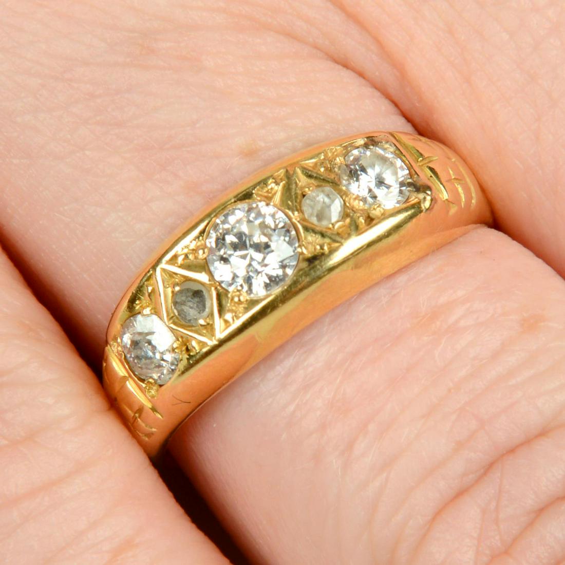 An early 20th century 18ct gold graduated diamond three-stone ring, with diamond point (1 of 5)