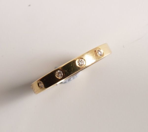 18ct gold five stone round brilliant diamond set b: 18ct gold five stone round brilliant diamond set band ring, each diamond flush set in a spaced front design. Total diamond weight - 0.11cts.