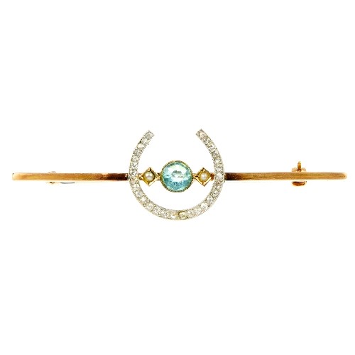 A diamond and paste horseshoe bar brooch. The circ: A diamond and paste horseshoe bar brooch. The circular-shape blue paste flanked by split pearls within a single-cut horseshoe surround to the plain bar. Stamped 9ct. Length 5.8cms.