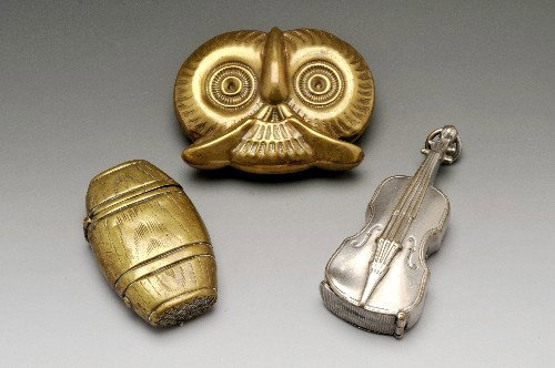 Three base metal novelty vesta cases.: Three base metal novelty vesta cases to include a white metal violin with hinged base and suspension loop measuring 65mm in length, a brass barrel with textured base and hinged lid and an owl's head w