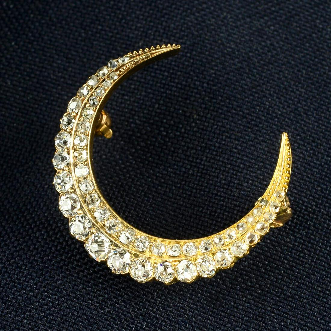 An early 20th century 18ct gold old and rose-cut diamond crescent brooch.Estimated total diamond (1 of 4)