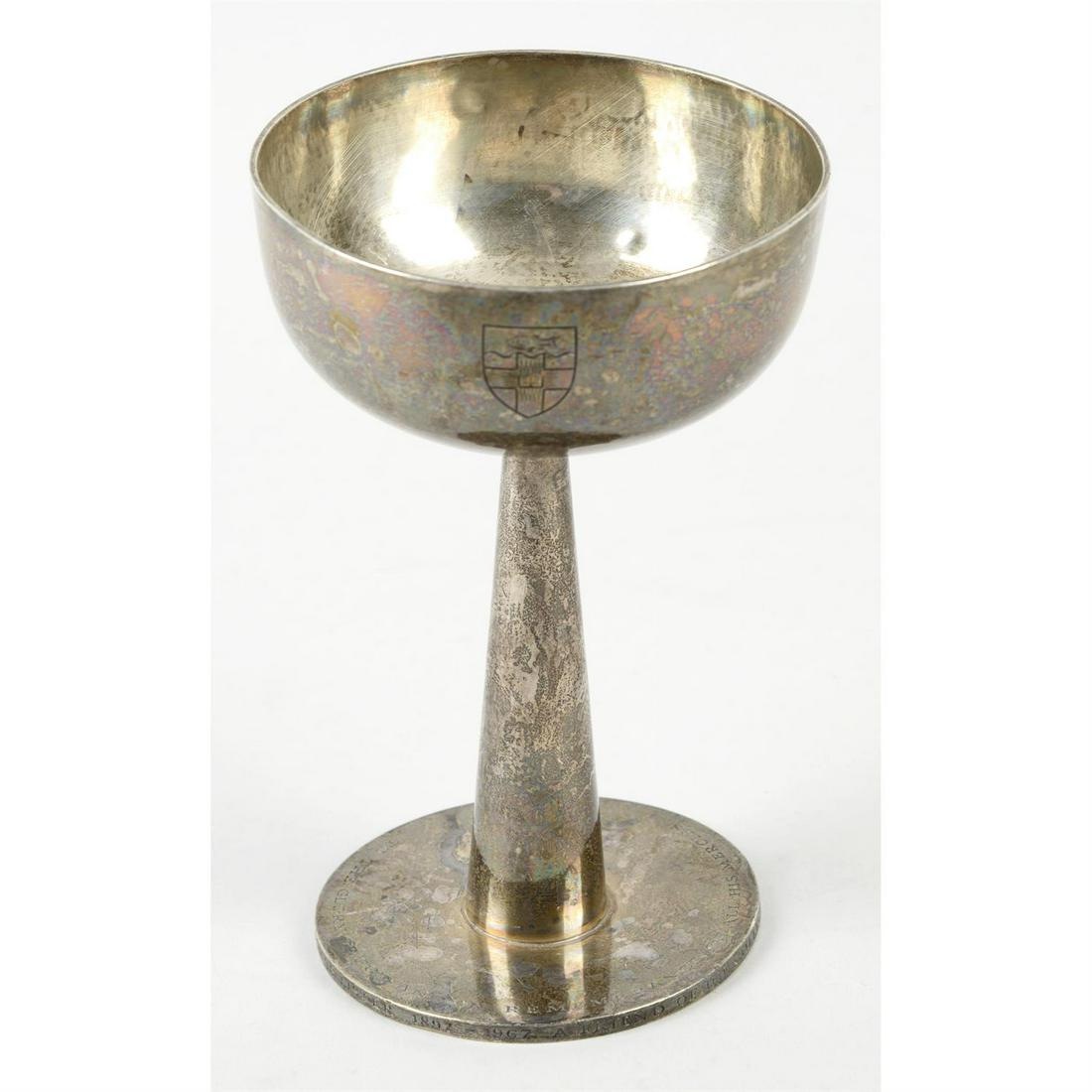 A modern silver chalice, with ecclesiastical engraving.: A modern silver chalice, the spread base with ecclesiastical engraving to edge, rising to a conical column and wide rimmed bowl having a central engraved crest. Hallmarked David Mellor, Sheffield