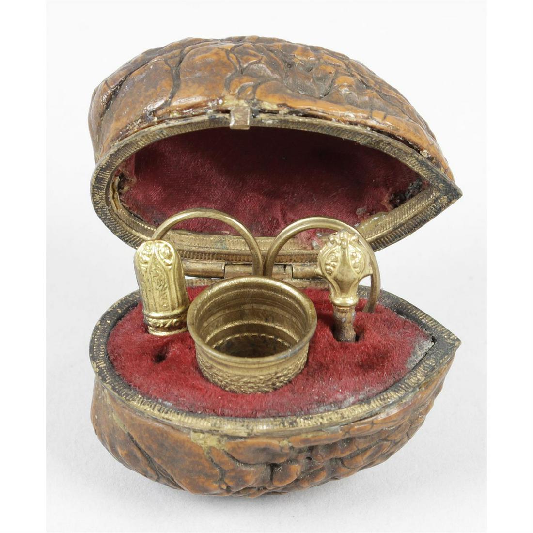 An unusual 19th century etui.: An unusual nineteenth century etui, the hinged case formed from the shell of a walnut, opening to reveal a pair of scissors, a thimble, a needle case, etc., width 2" (5cm) Condition Report: