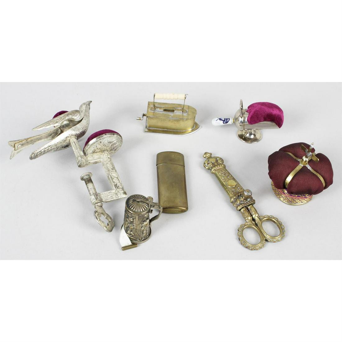 A small selection of assorted sewing related items.: A small selection of assorted sewing related items, to include novelty sewing tape measures modelled as a telephone, a pig, a beer stein, a flat iron, etc, together with sewing clamps, a needle case,