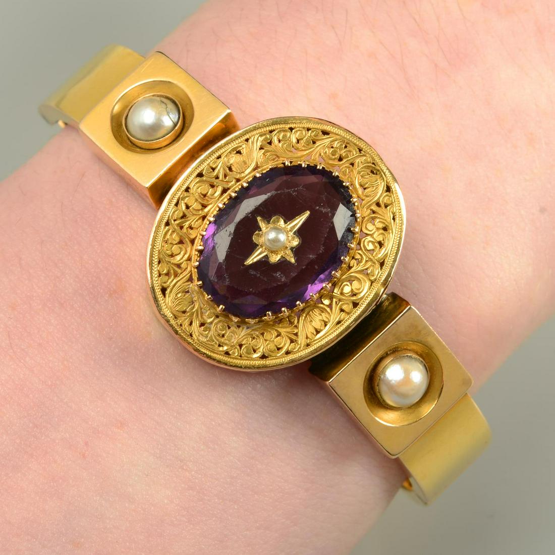 An early 20th century gold split pearl and purple paste bangle.Inner diameter 5.5cms. 19.9gms. (1 of 3)