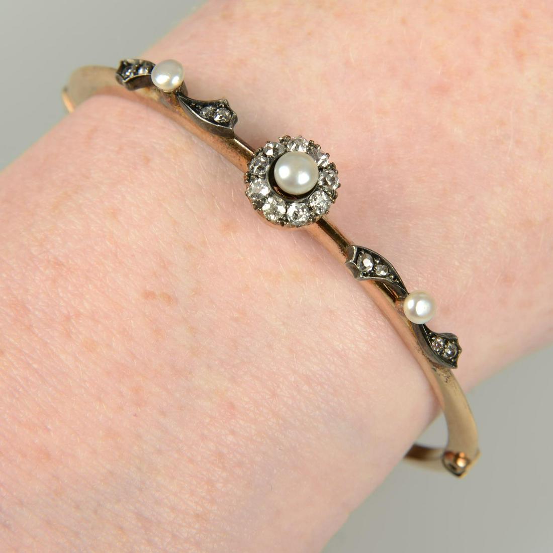 A late Victorian silver and gold, pearl and old-cut diamond floral cluster hinged bangle.Estimated (1 of 3)