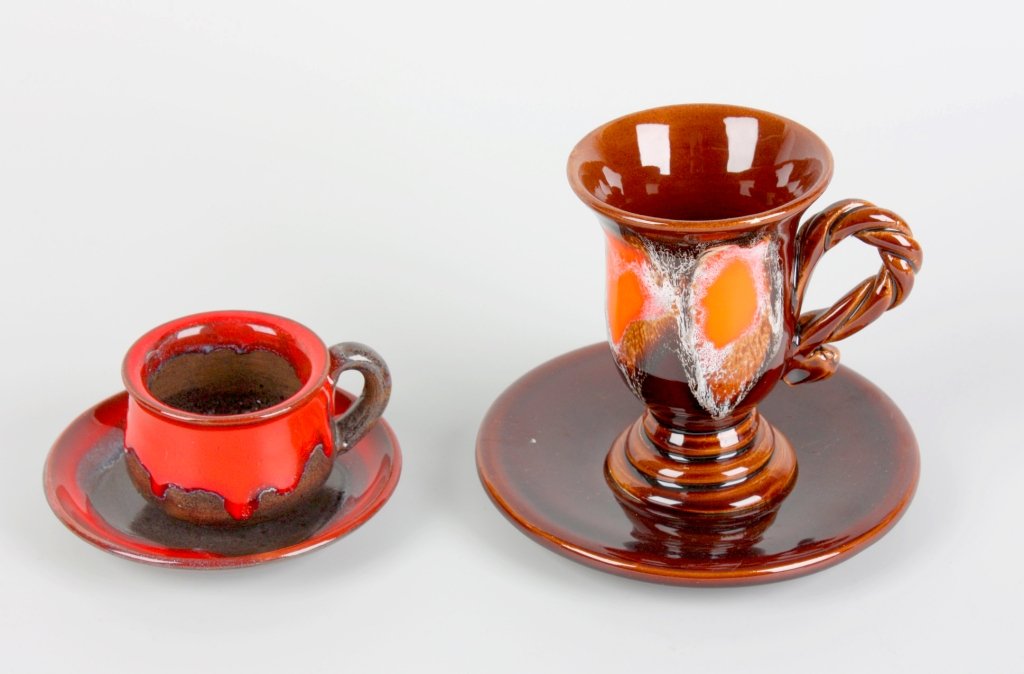 A two art pottery teasets: Two art pottery tea sets comprising: a Marius Giuge (Vallauris) coffee pot, two-handled sucrier, milk jug, six cups and saucers, four wavy edged plates and a matching platter, most pieces with orange