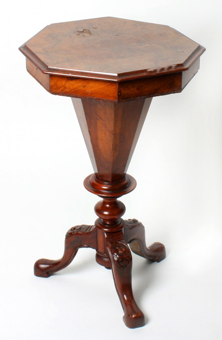 A late 19th century walnut veneered ladies sewing : A late 19th century walnut veneered ladies sewing table. The hinged octagonal top with moulded edge, opening to reveal a compartmented fitted interior. The whole upon on column and turned base with ca