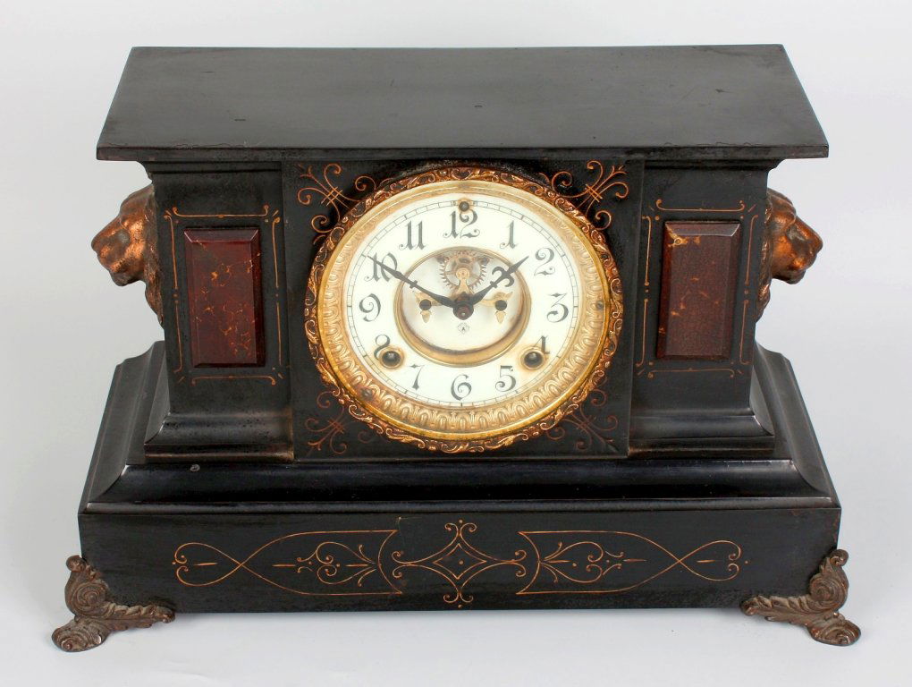Two late 19th century black slate mantel clocks: Two late 19th century black slate mantel clocks each with Arabic dial, one with partially visible Brocot escapement, one case with lion mask side ornaments, the other with ram's head, on paw feet, 10.