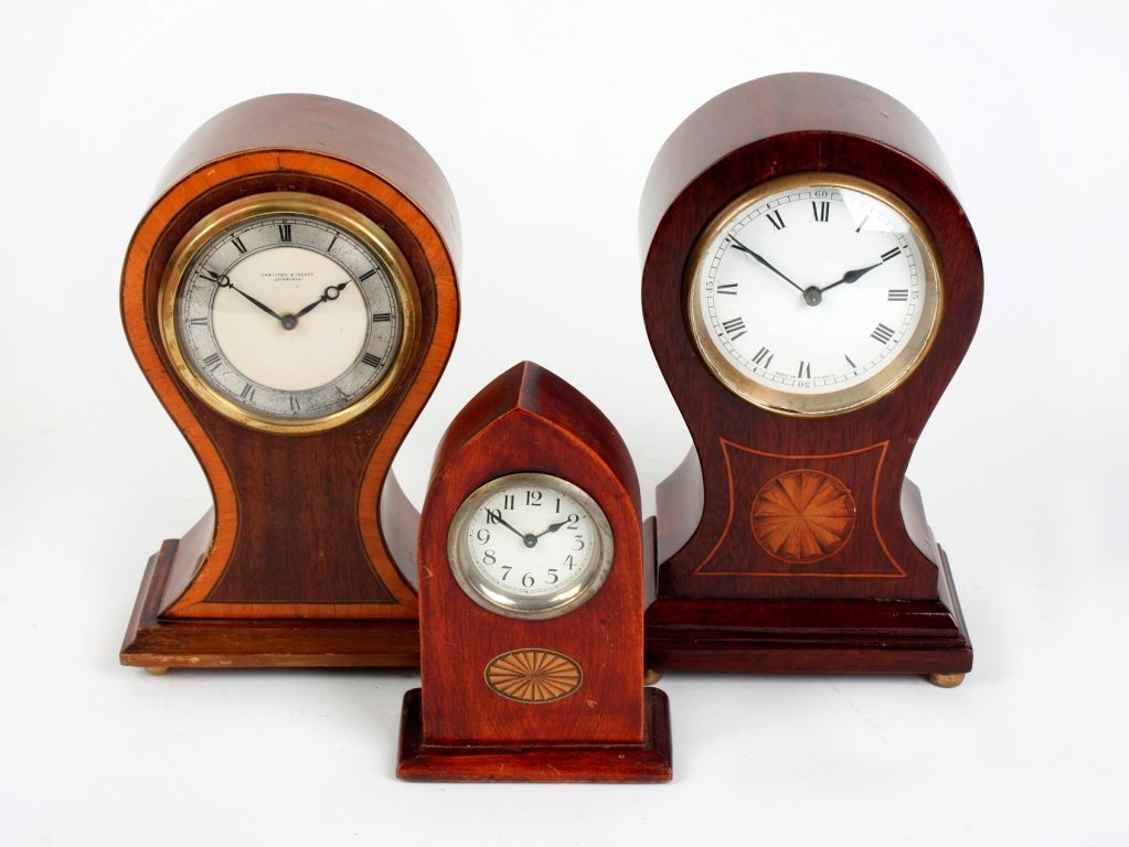 Two Edwardian inlaid mahogany balloon mantel clock: Two Edwardian inlaid mahogany balloon mantel clocks. The first retailed by Hamilton & Inches, Edinburgh, with silvered Roman chapter ring, moon hands and satinwood crossbanded border, 8.5" (21.5cm) hi
