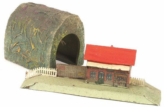 A wooden and cardboard Hornby 'O' gauge: A wooden and cardboard Hornby 'O' gauge straight tunnel section, together with a Bing 'O' gauge tinplate railway station, (a.f). (2).