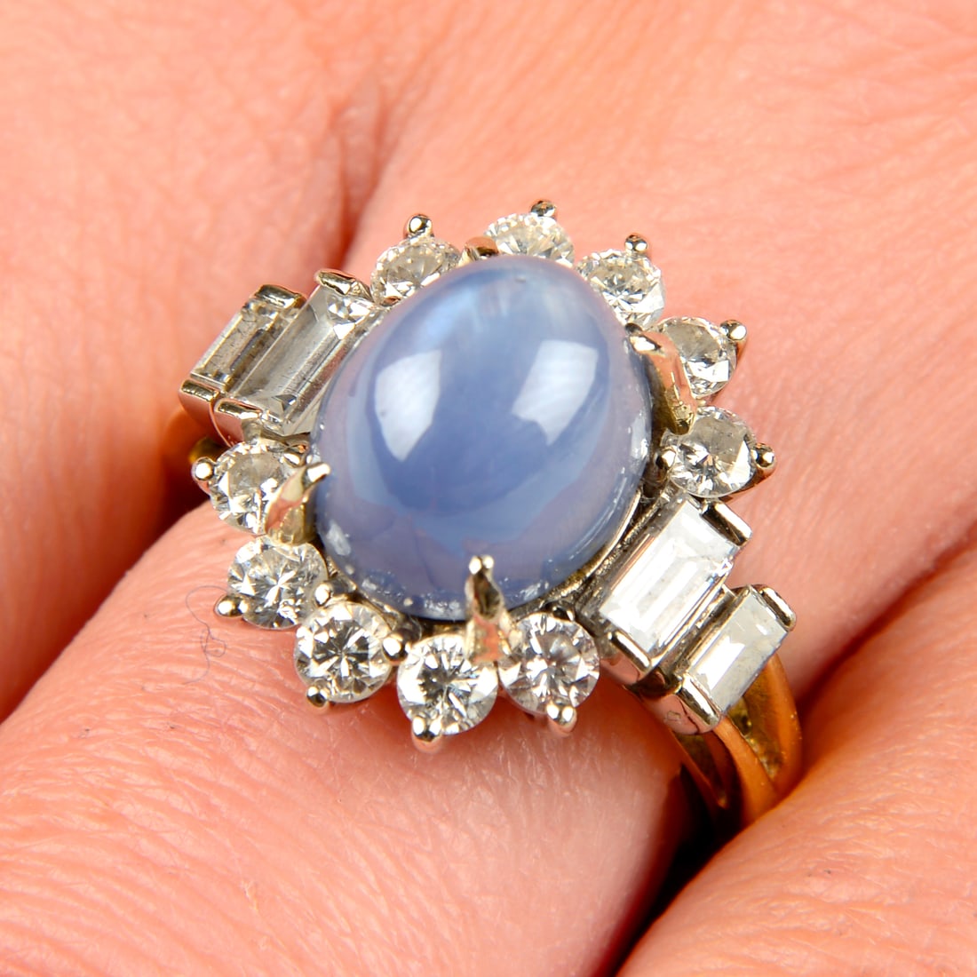 A star sapphire and vari-cut diamond cluster ring, by Grima.Marked GRIMA to inner sizing: A star sapphire and vari-cut diamond cluster ring, by Grima.Marked GRIMA to inner sizing aid.Sapphire calculated weight 8.40cts, based on estimated dimensions of 10.4 by 8.7 by 8.6mms.Estimated total