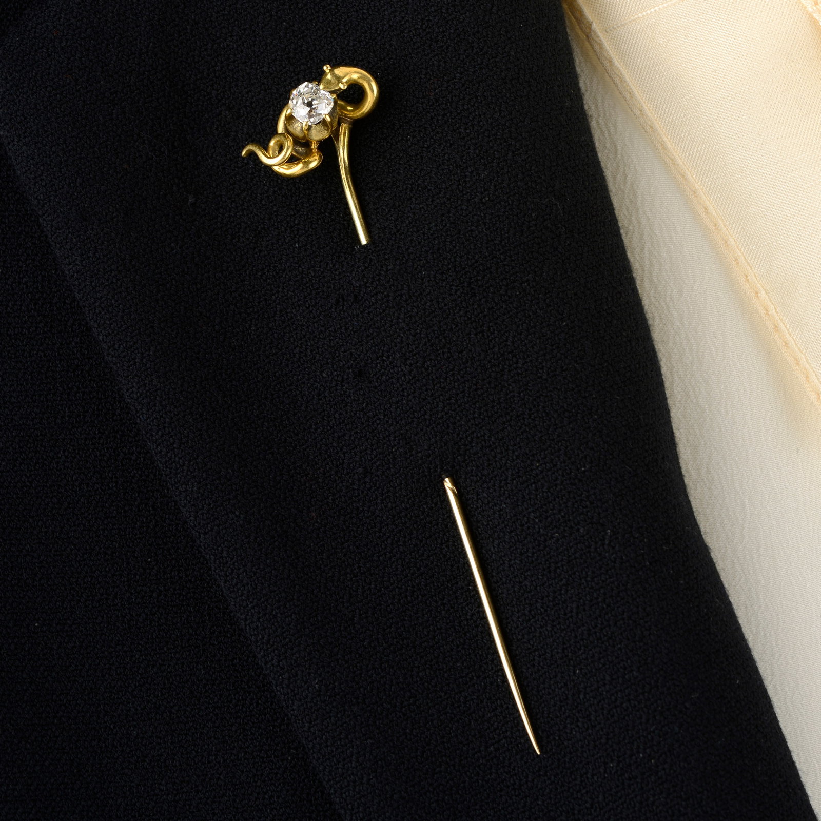 A Victorian gold old-cut diamond snake stickpin.Estimated diamond weight 0.45ct, H-I colour, P1: A Victorian gold old-cut diamond snake stickpin.Estimated diamond weight 0.45ct, H-I colour, P1 clarity.Length of stickpin head 1.7cms. 3.2gms.