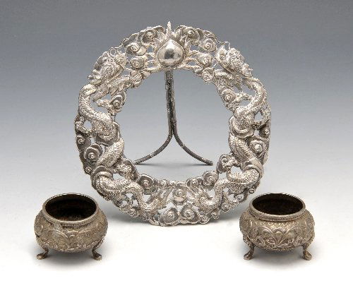 Oriental photograph frame & Asian open salts.: An Oriental white metal photograph frame of circular open work form depicting dragons amongst a floral border and easel back, missing components, marked with Oriental characters, height measuring 4 1/