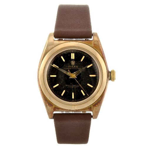 A 14k gold automatic gentleman's Rolex Oyster Perp: ROLEX - a 14k gold automatic gentleman's Oyster Perpetual bubble back wrist watch circa 1959, the black dial with hourly applied gilt batons, bordered by a minute track, tonneau shaped case, serial nu