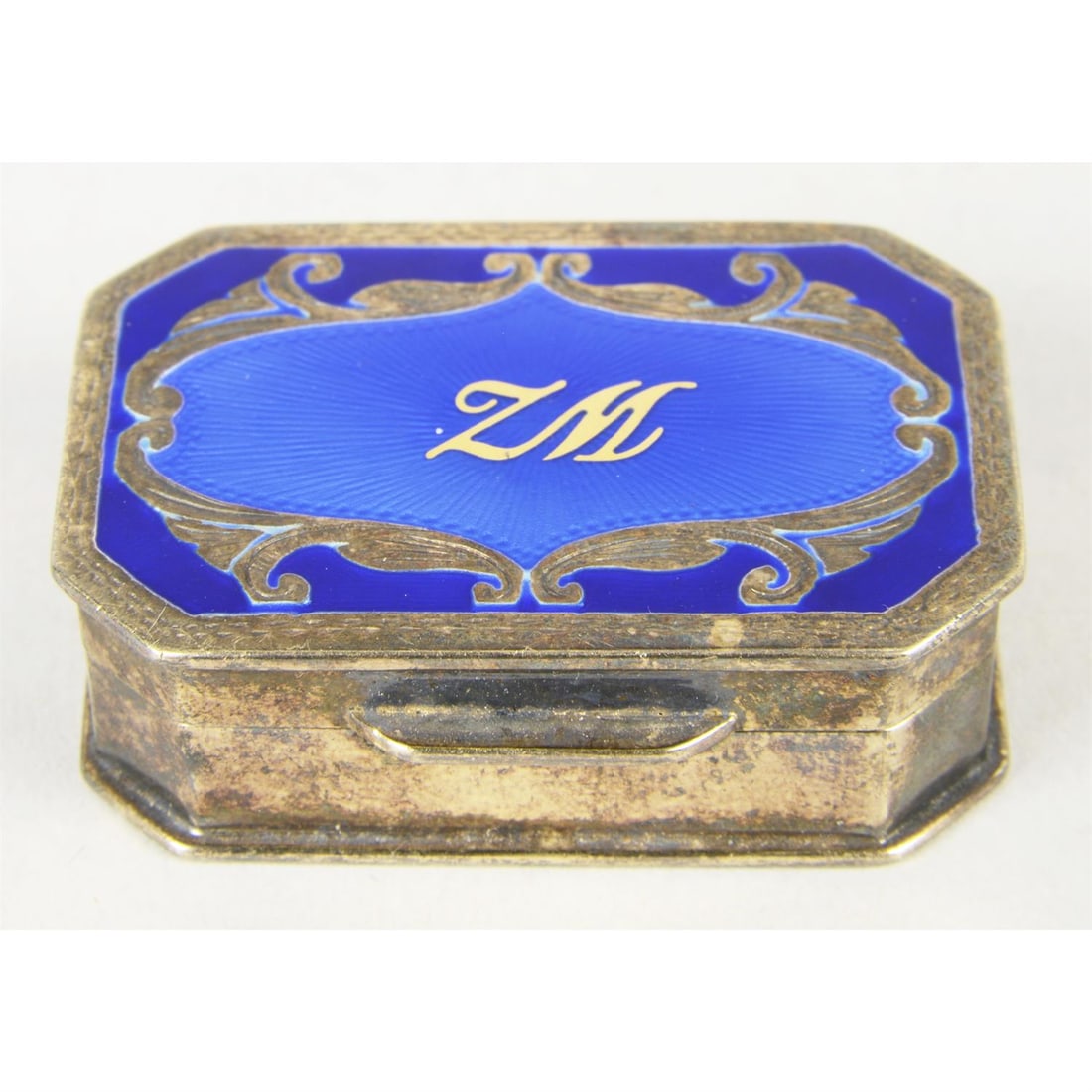 Italian silver-gilt & enamel pill box.: Italian silver-gilt and enamel pill box, of octagonal form with dark blue enamel surrounding central, bright blue guilloché enamel and monogram to hinged lid, having engraved decorative border en