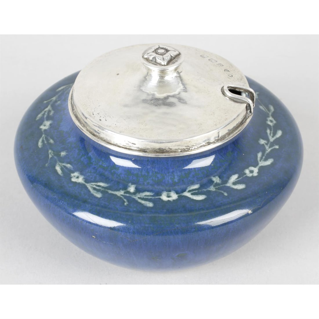 Ruskin Pottery bowl with A.E Jones silver cover: An early 20th century Ruskin Pottery soufflé glaze bowl decorated in a tonal blue with painted garland to the shoulder, painted scissor mark to the base and dated 1914, the hallmarked silver plan