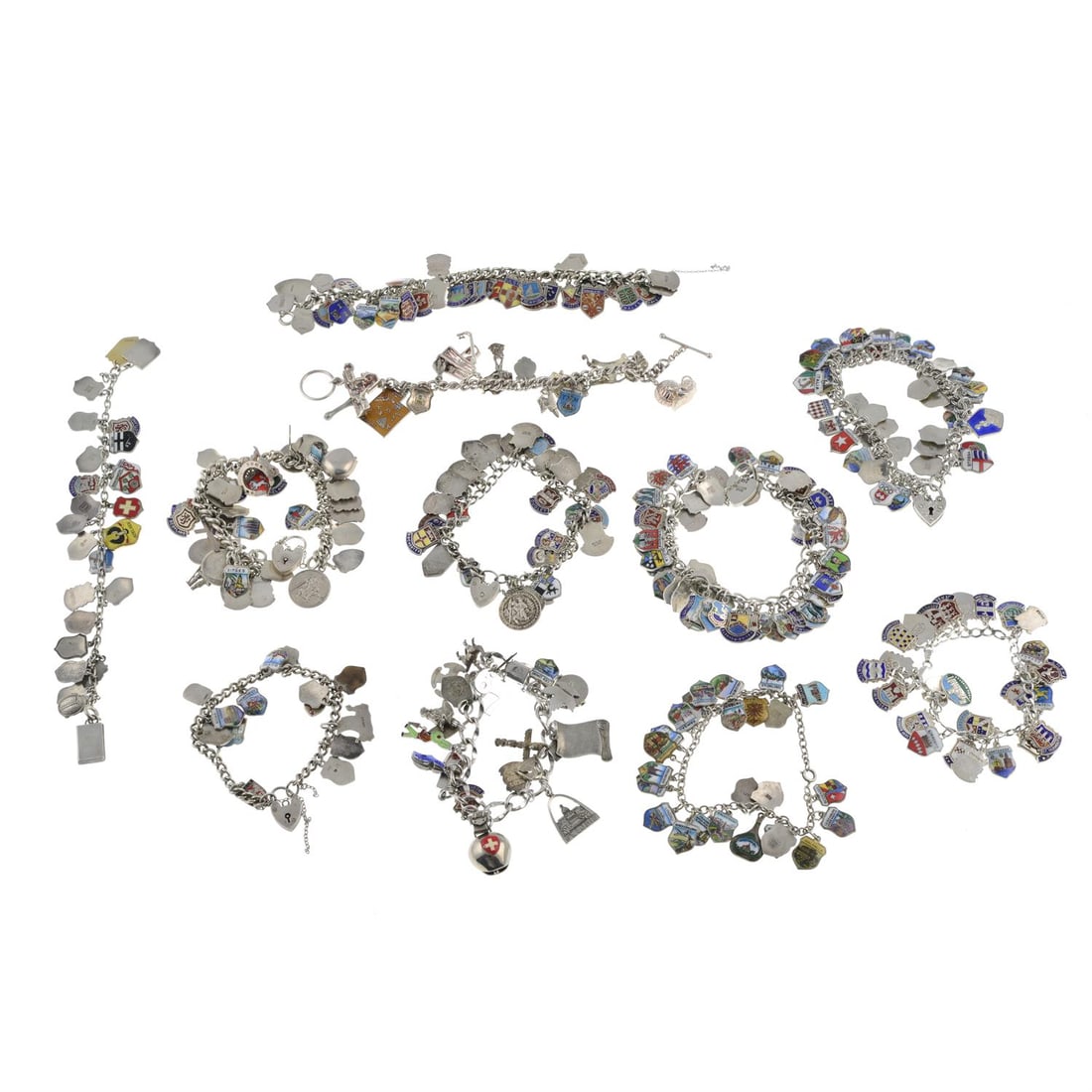 Eleven silver charm bracelets: Eleven silver charm bracelets, mostly enamelled. Total number of charms 328. Seventy-four charms, four bracelets and two heart clasps stamped approximately sterling, sixty-four charms and one heart cl