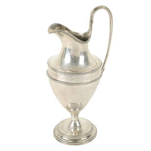 George III silver pedestal milk or cream jug by Hester Bateman.: A George III silver pedestal milk or cream jug, of vase form to a circular foot, with beaded rim and border detail and monogrammed oval cartouche, and the tall loop handle with foliate terminal. Hallm