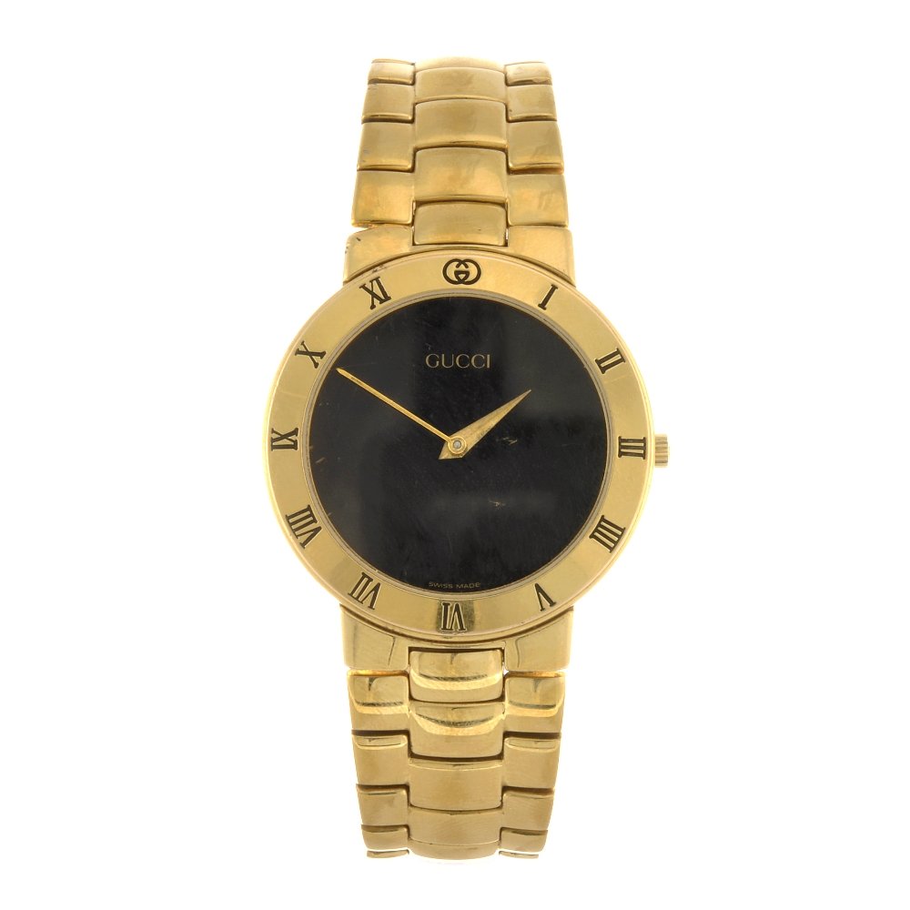 A gold plated quartz gentleman's Gucci 3300.2M brac: GUCCI - a gold plated quartz gentleman's 3300.2M bracelet watch, the plain black dial, circular shaped case with black Roman chapter ring to front, numbered 0134824, fitted to a gold plated link brace