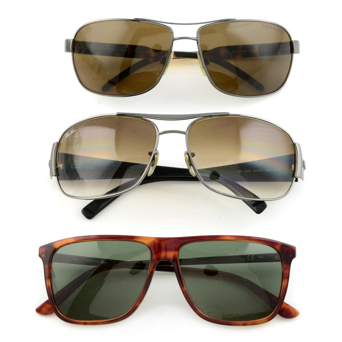 Mixed brands - three pairs of sunglasses.: Mixed brands - three pairs of sunglasses. Ray-Ban, Polo Ralph Lauren and Lacoste. With three maker`s cases. Condition Report: Fair condition Scuffing and scratches on lenses General signs