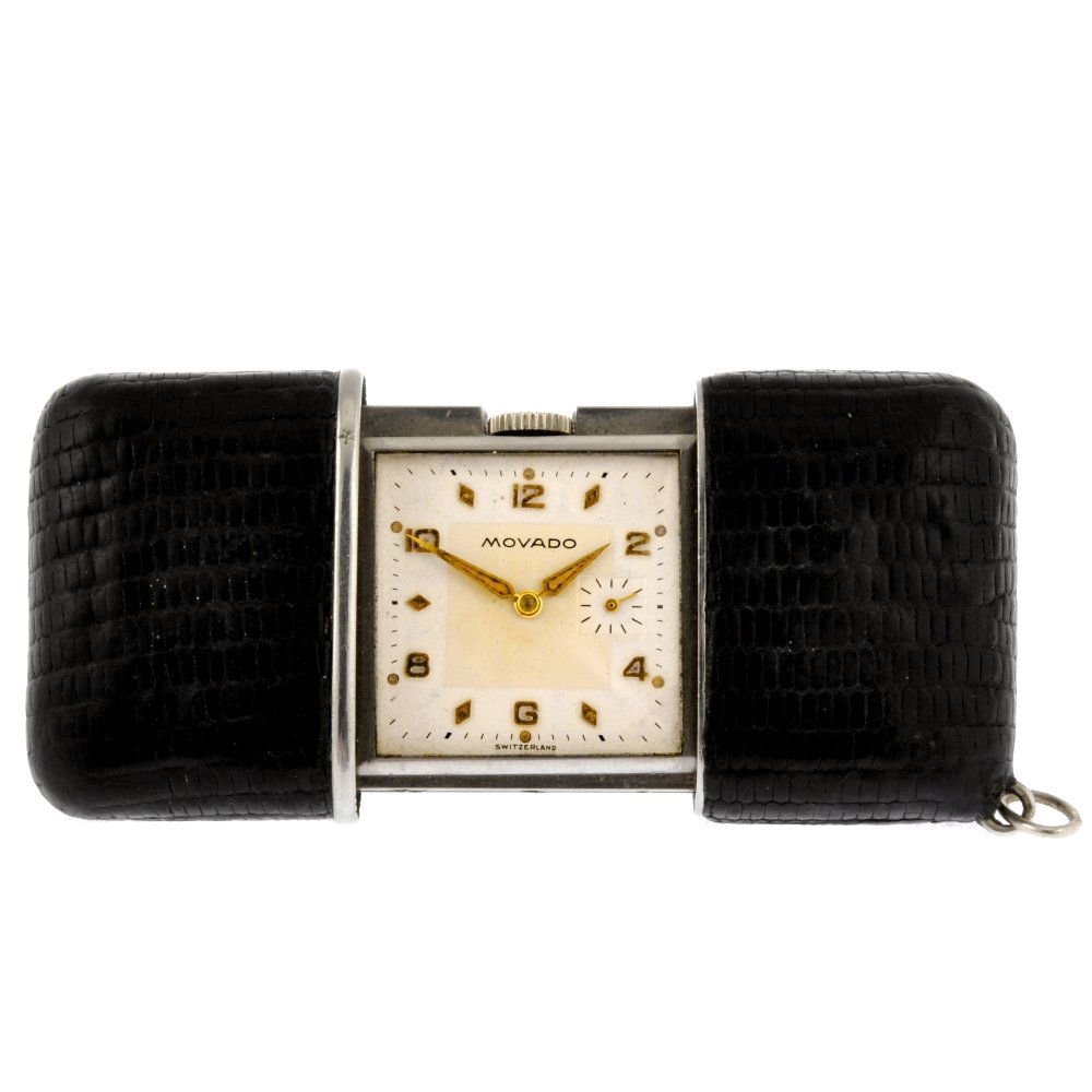 A stainless steel manual wind travel clock signed: A stainless steel manual wind travel clock signed Movado, the silvered dial with hourly markers, interspaced with Arabic numerals, bordered by a minute track, subsidiary seconds dial positioned to thr