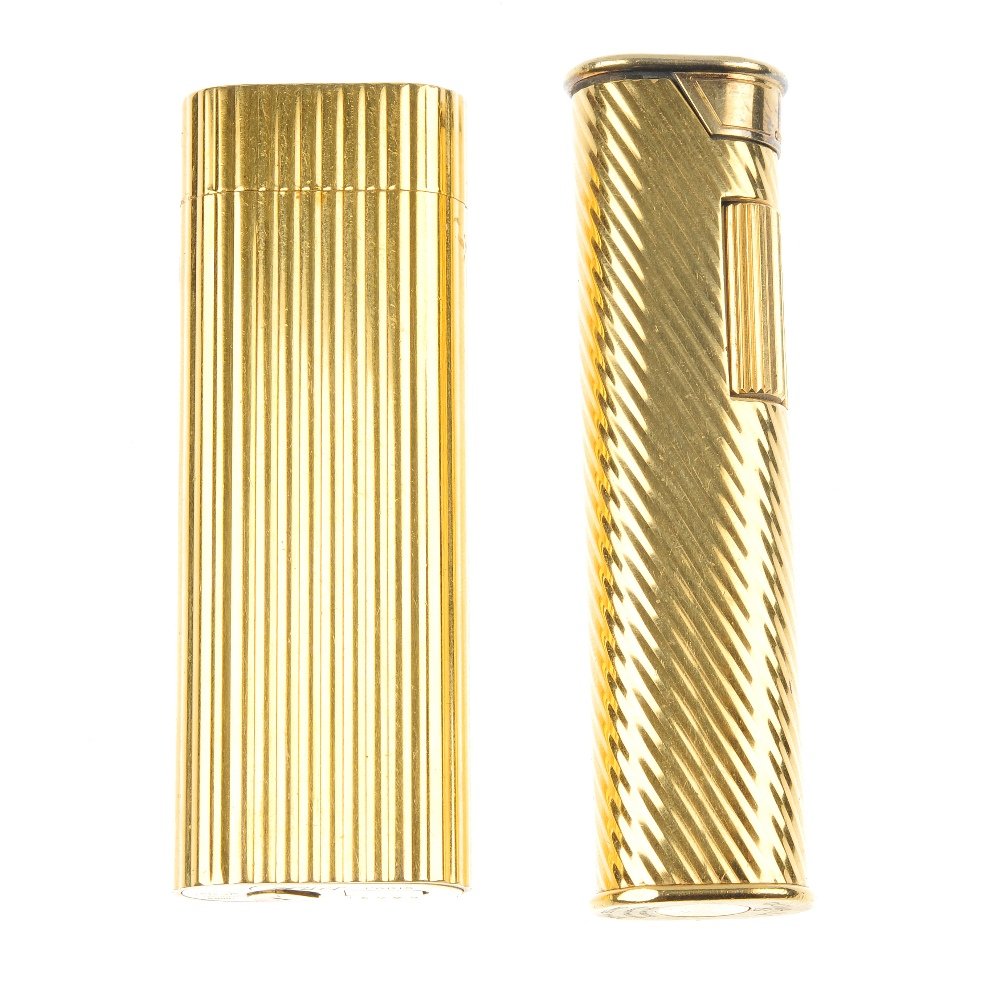 Two gold plated lighters: Two gold plated lighters, to include a Cartier gas lighter with reeded case and a Dunhill gas lighter with diagonal groove detail case. One signed Cartier Paris. One signed Dunhill swiss made. Lengths