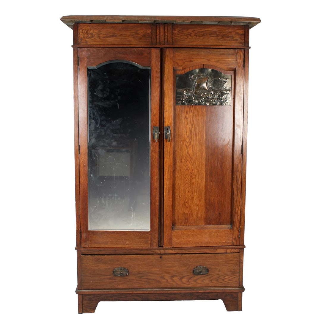 Arts and Crafts wardrobe with inset copper panel: An early 20th century Arts and Crafts oak wardrobe, the double doors with a mirror panel and a repousse copper panel depicting a galleon at sail, in the manner of John Pearson, the interior with hangi