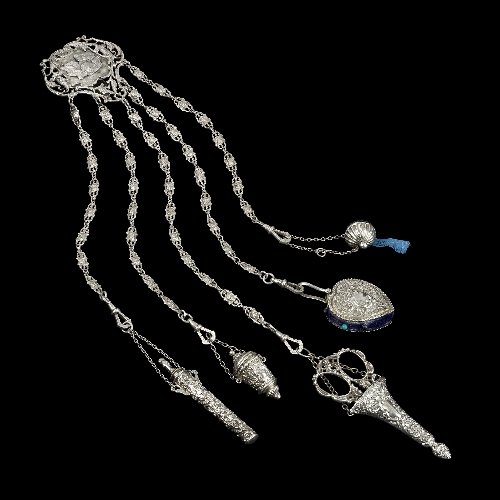 Turn of the century silver chatelaine.: Turn of the century silver chatelaine, the belt clip of open work scroll surround, central stylised images of putti, five suspension chains formed as putto mask links, supporting a tape measure hallma