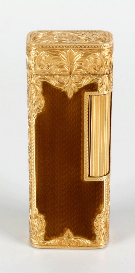 A Dunhill gold and enamelled cased gas cigarette: A Dunhill gold and enamelled cased gas cigarette lighter with engraved scrolled detail and brown enamelled panels