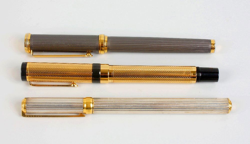 Three various pens: Three various pens. Comprising: an S. T. Dupont fountain pen, with ribbed silvered body, monogrammed gilt clip over collar marked "S.T. Dupont PARIS", the nib marked "18K D 750 M", 5.5", (14cm) long;