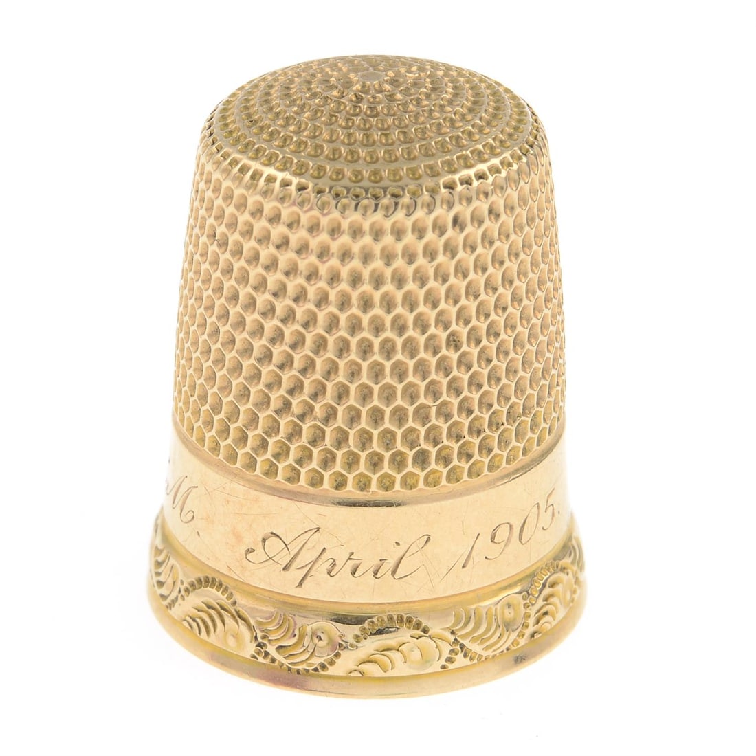 Edwardian gold thimble: An Edwardian gold thimble. Length 2cm. 3.8gm. Condition Report: Some surface scratches/wear. With personal engraving, 'E.M. April 1905.'