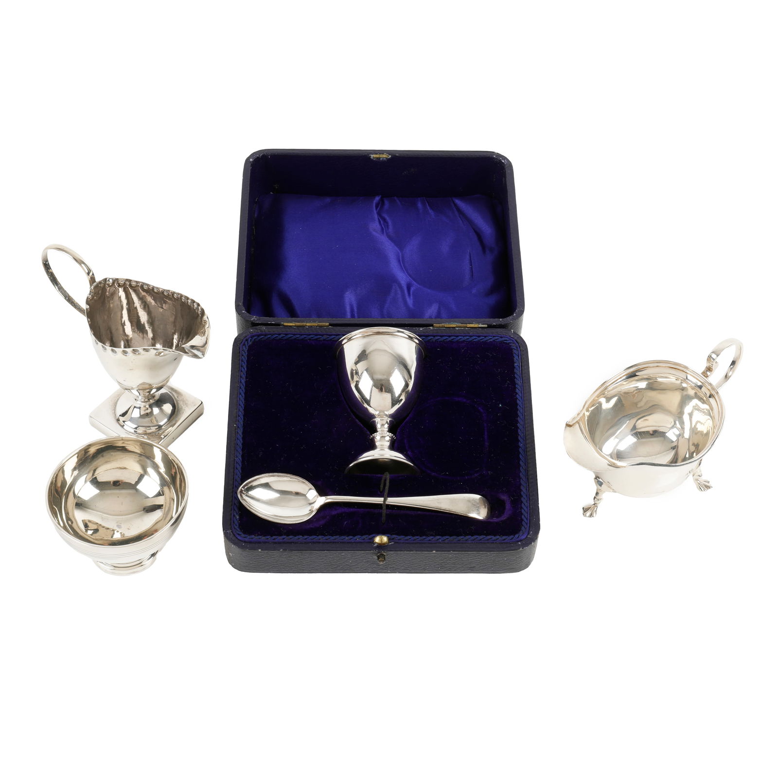 Cased egg cup set, plus two cream jugs & salt: Cased egg cup set, plus two cream jugs & salt A late Victorian silver pedestal cream jug, of helmet shape with punch beaded border, hallmarked George Nathan & Ridley Hayes, Chester 1896, height to