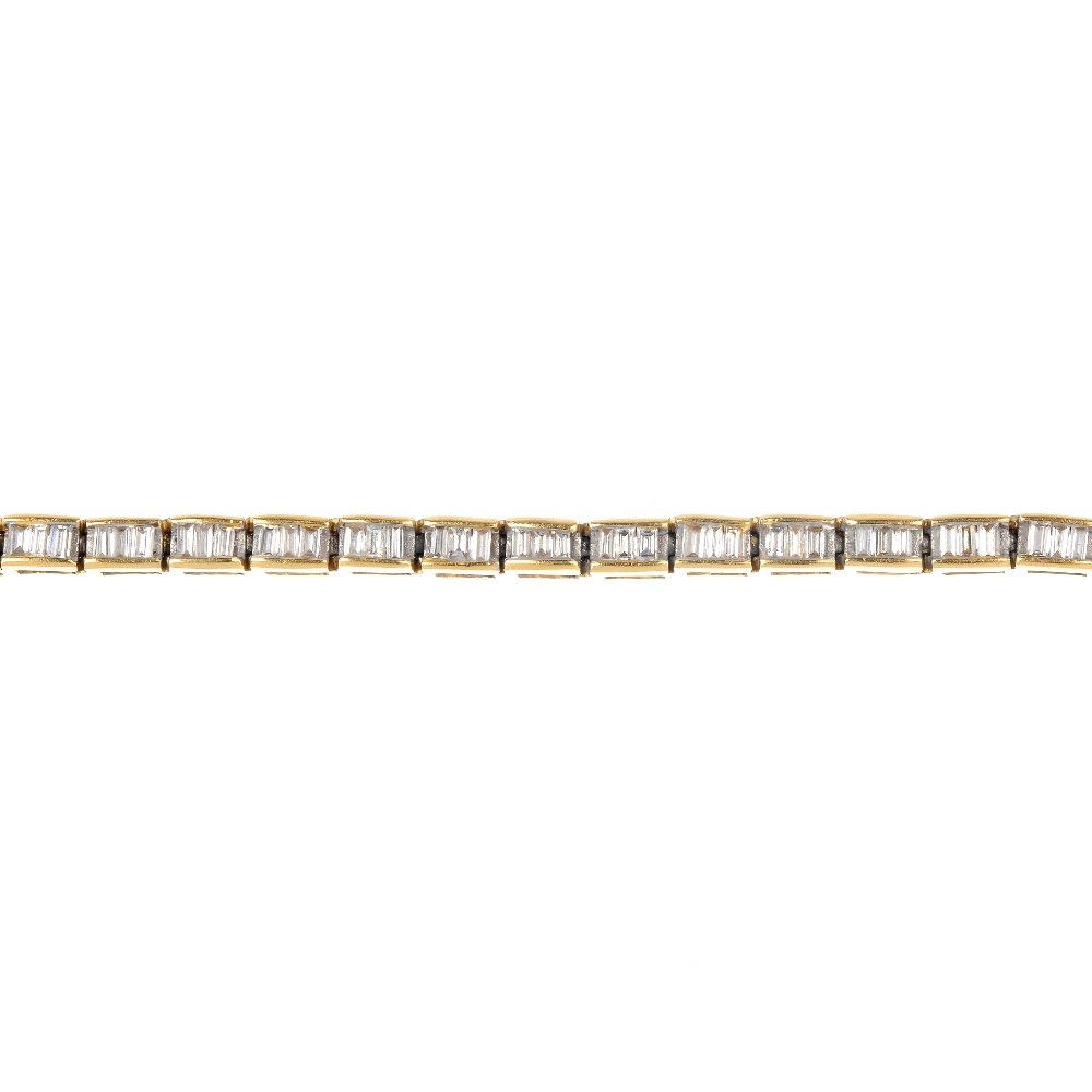 An 18ct gold diamond line bracelet.: An 18ct gold diamond line bracelet. Designed as a series of diamond three-stone rectangular-shape links, each within a channel setting, to the push-piece clasp. Estimated total diamond weight 1ct. Hal