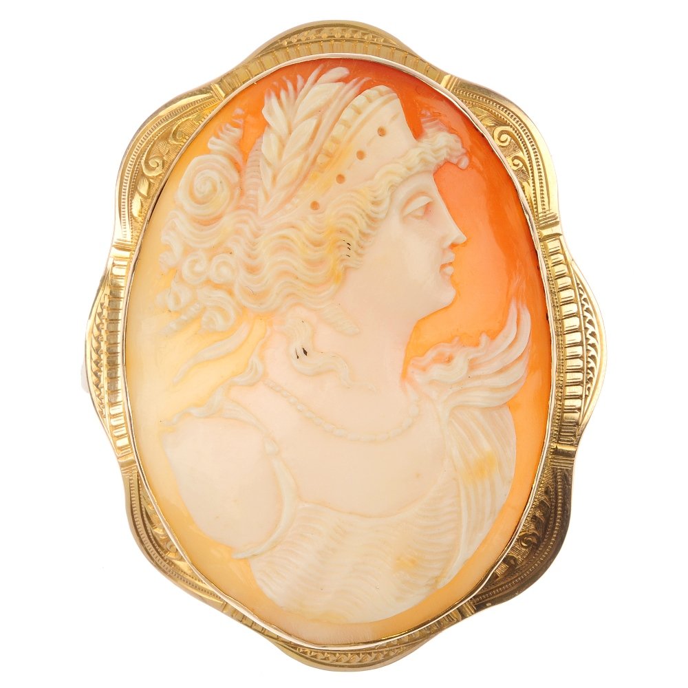 A mid 20th century 9ct gold shell cameo brooch: A mid 20th century 9ct gold shell cameo brooch, of oval outline, carved to depict the profile of a lady, within a detailed scalloped surround. Length 6.5cms. Weight 21gms.