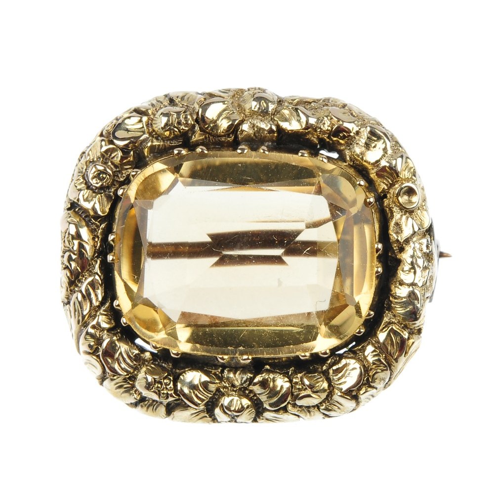 A late Victorian citrine brooch, circa 1870 and an Edwa: A late Victorian cushion-cut citrine brooch, within a floral surround, circa 1870, together with an Edwardian 9ct gold double-sided photographic locket. One with hallmarks for Birmingham, 1905. Length