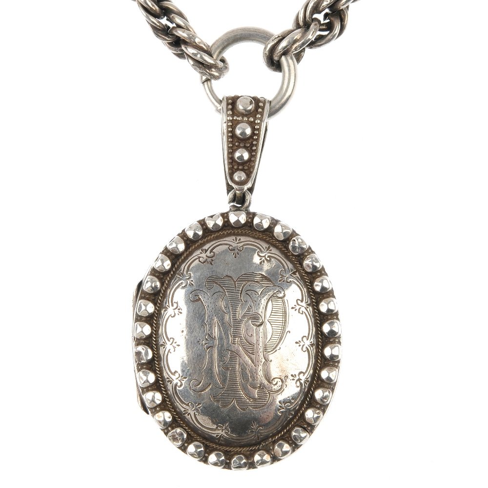 A late Victorian silver locket and chain, circa 1880.: A late Victorian silver locket, circa 1880, of oval outline, with engraved monogram and personal inscription, with faceted bead surround and surmount, suspended from a rope-twist chain. Length of lock