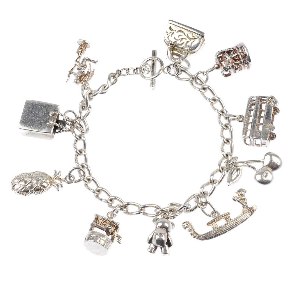 A selection of silver and white metal charm bracelets a: A selection of silver and white metal charm bracelets and charms, to include a bracelet with suspended charms, to include a bus and a pineapple and a curb-link bracelet with padlock clasp. (55)Thirty-