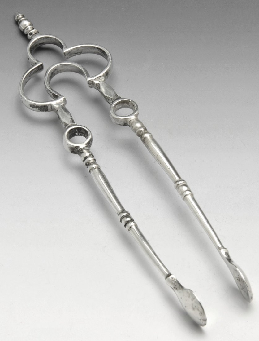 Edwardain silver pair of sugar tongs, unusual form.: Edwardian silver pair of sugar tongs of unusual form, with openwork trefoil shape terminal leading to knopped slender stems and plain grips. Hallmarked Thomas Bradbury & Sons Ltd., Sheffield 1908. Len