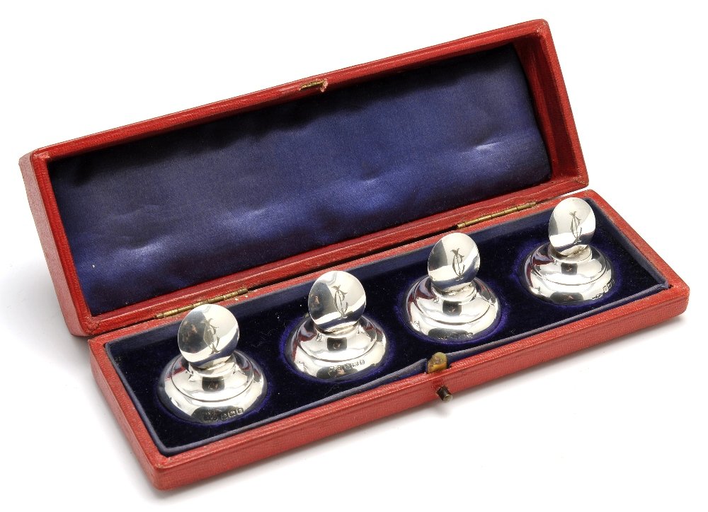 A cased set of four Edwardian silver menu/name holders.: A cased set of four Edwardian silver menu/name holders of plain domed circular form with engraved monogram and raised on a circular tapered base. Hallmarked Charles Penny Brown Birmingham 1906. Height