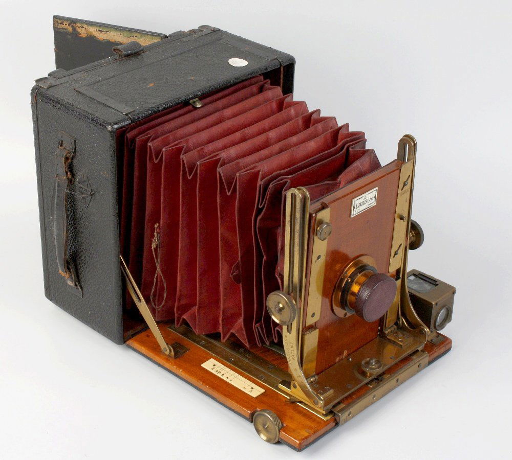 A Sanderson folding plate camera and an incomplete fold: A Sanderson folding plate camera. The black leather covered and mahogany case with brass fittings and folding red leather bellows, impressed Sandersons Patent and numbered 1414, together with an incom
