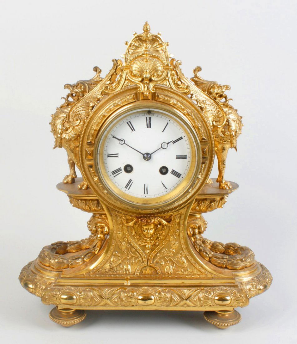 A French ormolu mantel clock: A late 19th century French ormolu mantel clock having a 3.5" Roman dial with Breguet moon hands, the unmarked two train movement half hour striking on a bell, the elaborate case with cast dragons over